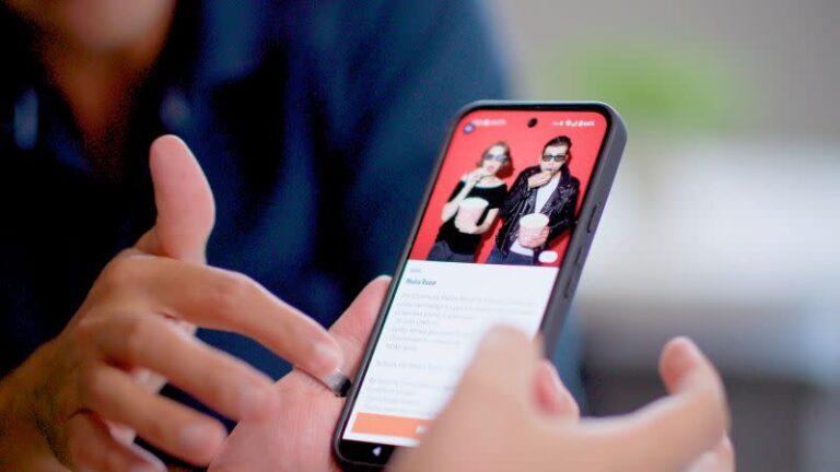Hands holding a smartphone with the screen displaying a property and resident app.